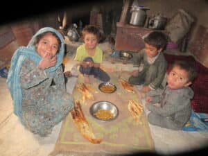 Refugee children eating soy naan and soy qorma